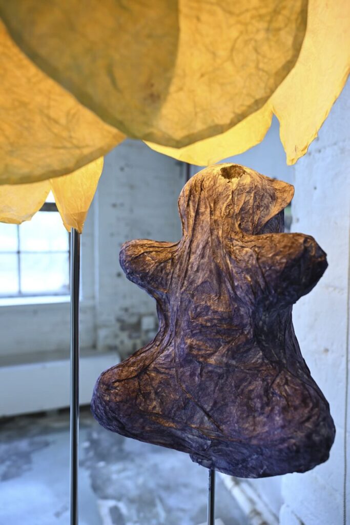 Paper sculpture with a weird violet animal and yellow flower like structure